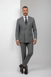 Man wearing gray double-breasted suit with tailored fit and brown leather shoes.